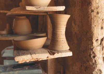 Handcrafted clay pottery displayed on rustic wooden shelves capturing the essence of traditional art.